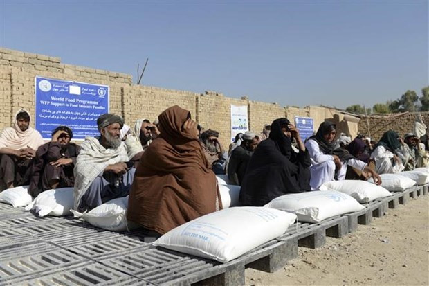 Người dân Afghanistan nhận lương thực viện trợ từ Chương trình Lương thực thế giới, tại Kandahar. (Ảnh: AFP/TTXVN) LHQ thúc đẩy tạo nguồn tài chính giải quyết khủng hoảng ở Afghanistan ảnh 1
