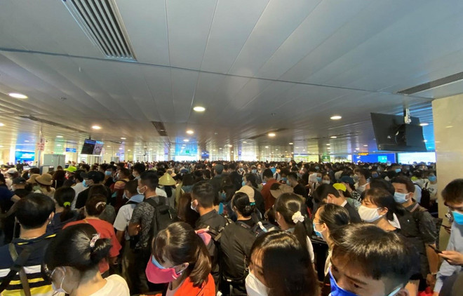 Hành khách xếp hàng dài chờ làm thủ tục lên máy bay tại sân bay Tân Sơn Nhất. (Ảnh: CTV/Vietnam+) Vì sao sân bay Tân Sơn Nhất lại bị ùn tắc tại khu vực soi chiếu? ảnh 1