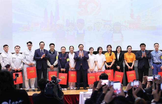 Thủ tướng Phạm Minh Chính tặng quà cho đại diện thực tập sinh và người lao động đang làm việc tại Nhật Bản. (Ảnh: Dương Giang/TTXVN) TTXVN_2906laodongVietnamNhatban.jpg