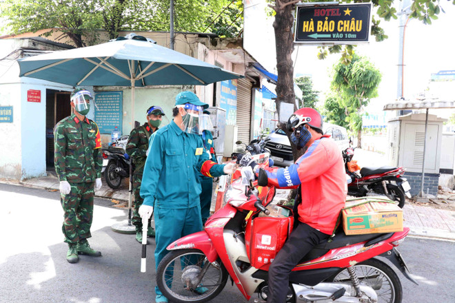 Lực lượng dân quân tham gia kiểm soát tại các chốt chặn phòng dịch trong thời gian Thành phố Hồ Chí Minh giãn cách xã hội. (Ảnh: Xuân Khu/TTXVN) Những cống hiến thầm lặng của những chiến sỹ dân quân tự vệ TP.HCM ảnh 1