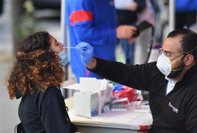 Nhân viên y tế lấy mẫu xét nghiệm COVID-19 cho người dân tại New York, Mỹ. (Ảnh: AFP/TTXVN) Omicron cũng nguy hiểm như các biến thể trước đó của virus SARS-CoV-2 ảnh 1