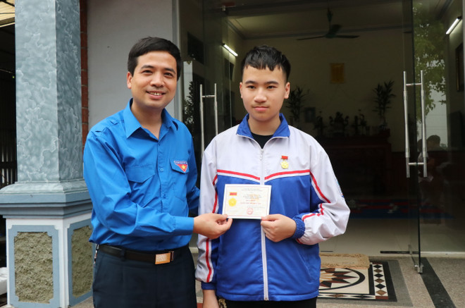 Bí thư Tỉnh Đoàn Bắc Ninh Nguyễn Đức Sâm trao tặng Huy hiệu Tuổi trẻ dũng cảm cho em Nguyễn Văn An. (Ảnh: Đinh Văn Nhiều/TTXVN) Trao tặng huy hiệu Tuổi trẻ dũng cảm cho học sinh cứu người đuối nước ảnh 1