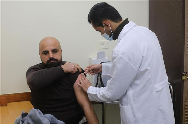Nhân viên y tế tiêm vaccine phòng COVID-19 cho người dân tại Rafah, Dải Gaza, ngày 20/3/2022. (Ảnh: THX/TTXVN) Chuyên gia: Khả năng vaccine COVID-19 sẽ trở thành mũi tiêm định kỳ ảnh 1