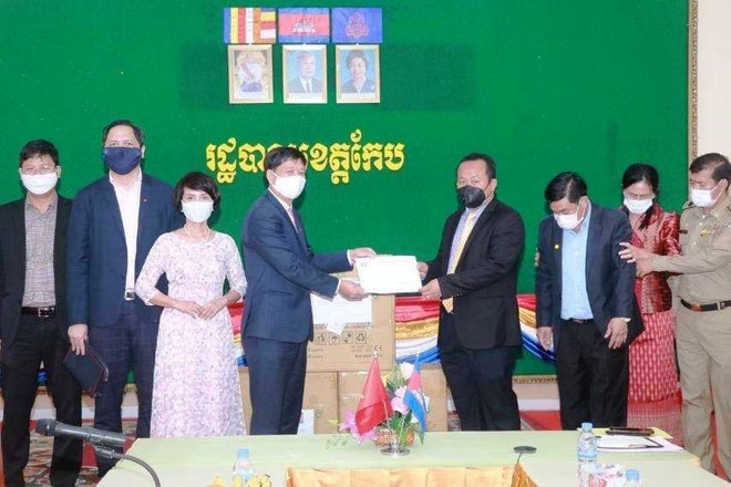 Tỉnh trưởng Kep Som Piseth (phải) nhận tượng trưng vật tư chống dịch COVID-19 của Quỹ hỗ trợ cộng đồng tại Campuchia. (Ảnh: Trần Long/TTXVN) Tăng cường công tác bảo hộ công dân, hỗ trợ người gốc Việt ở Campuchia ảnh 1