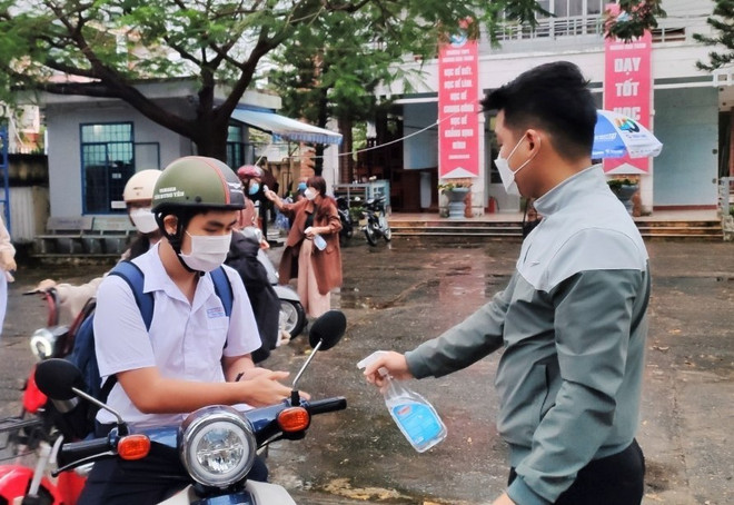 Học sinh trường THPT Hoàng Hoa Thám xịt sát khuẩn tay tại cổng trường. (Ảnh: Văn Dũng/TTXVN) Đà Nẵng cho phép học sinh lớp 8-9 và lớp 1 đi học lại vào ngày 6/12 ảnh 1