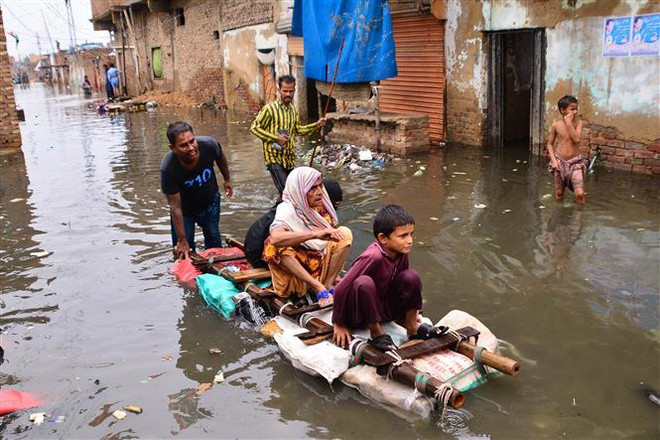 Người dân tại khu vực bị ảnh hưởng bởi mưa lũ ở Hyderabad, Pakistan ngày 19/8/2022. (Ảnh: AFP/TTXVN) Pakistan cảm kích cộng đồng quốc tế hỗ trợ khắc phục hậu quả lũ lụt ảnh 1