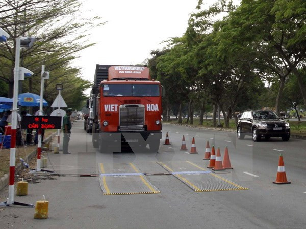 Kiểm tra phương tiện container tại trạm cân đường Nguyễn Văn Linh, quận 7, Thành phố Hồ Chí Minh. (Ảnh: Hoàng Hải/TTXVN) Bộ trưởng GTVT: Chỉ có Việt Nam mới có xe đi lùi đường cao tốc ảnh 2