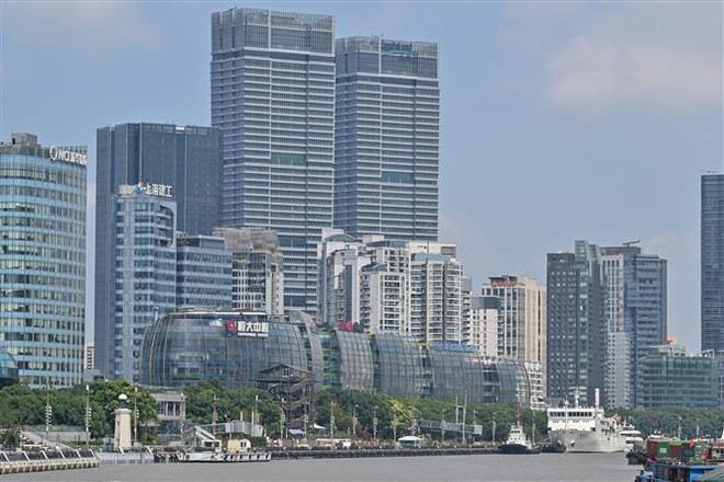 Tòa nhà của tập đoàn Evergrande (giữa) tại Thượng Hải, Trung Quốc, ngày 24/9. (Ảnh: AFP/ TTXVN) Giá cổ phiếu của Evergrande lao dốc sau gần 3 tuần bị ngừng giao dịch ảnh 1