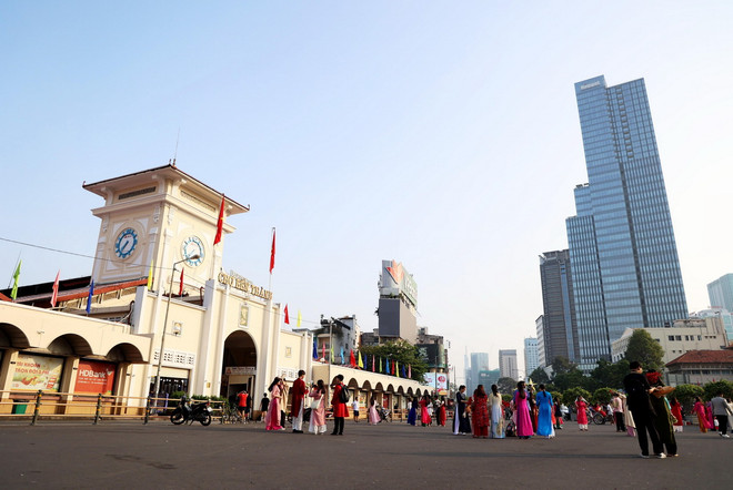 Người dân, khách du lịch chụp ảnh kỷ niệm trước Chợ Bến Thành. (Ảnh: Hồng Đạt/TTXVN) thanh pho ho chi minh.jpg