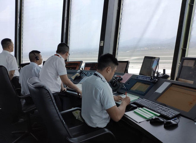 Nhân viên Kiểm soát viên không lưu tại Đài Kiểm soát không lưu Nội Bài điều hành các chuyến bay đi, đến. (Ảnh: Việt Hùng/Vietnam+) Nghề Kiểm soát viên không lưu: Những người ‘lái’ phi công trên trời ảnh 1