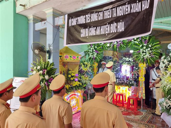 Đoàn công tác Cục Cảnh sát giao thông viếng Thiếu tá Nguyễn Xuân Hào. (Ảnh: Bùi Giang/TTXVN) Long An: Thu giữ lượng lớn ma túy trong vụ lao xe vào CSGT ảnh 1