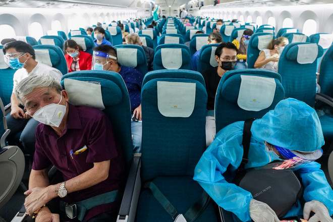 Hành khách trên chuyến bay của Vietnam Airlines thực hiện ngồi giãn cách ghế theo đúng quy định. (Ảnh: CTV/Vietnam+) Cục Hàng không đề xuất tăng tần suất 3 đường bay lớn nhất cả nước ảnh 1