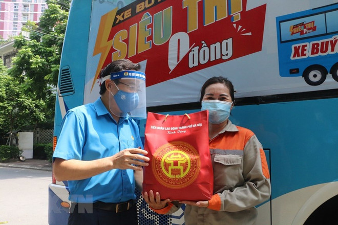 Lãnh đạo tổ chức Công đoàn Thủ đô trao quà hỗ trợ khó khăn cho người lao động Thủ đô khó khăn bởi dịch bệnh COVID-19. (Ảnh: TTXVN phát) Thủ đô những ngày giãn cách: Ấm áp những tấm lòng thiện nguyện ảnh 1