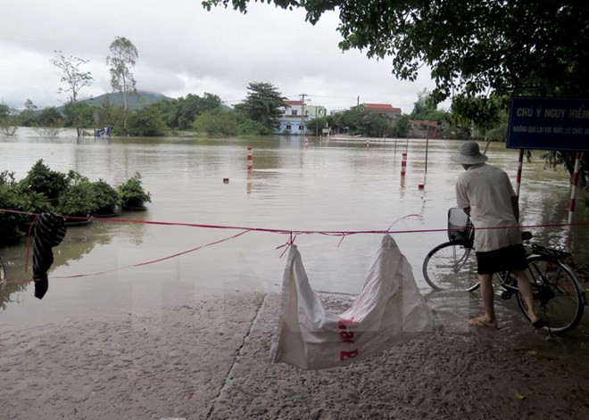 Đập trần Bến Ngựa nối xã Nhơn Hưng với xã An Nhơn, thị xã An Nhơn đã bị nước lũ chia cắt. (Ảnh: Viết Ý/TTXVN) Bình Định: Mưa lũ làm 6 người chết và mất tích, nhiều nơi ngập nặng ảnh 1