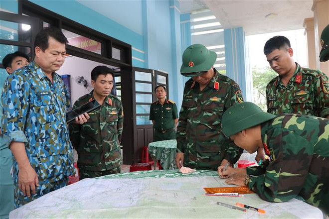 Ban chỉ đạo Sở chỉ huy tiền phương nghiên cứu phương án để tiếp cận hiện trường Rào Trăng 3. (Ảnh: Đỗ Văn Trưởng/ TTXVN) Huy động máy móc từ cao tốc Bắc-Nam ứng cứu sự cố Rào Trăng 3 ảnh 2