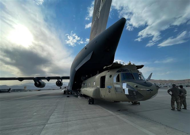 Máy bay trực thăng CH-47 Chinook được chuyển lên máy bay vận tải C-17 Globemaster III của Không lực Mỹ tại sân bay quốc tế Hamid Karzai ở Kabul, Afghanistan, ngày 28/8/2021. (Ảnh: THX/TTXVN) Mỹ xác định tạm ngừng hiện diện ngoại giao tại Kabul ảnh 1