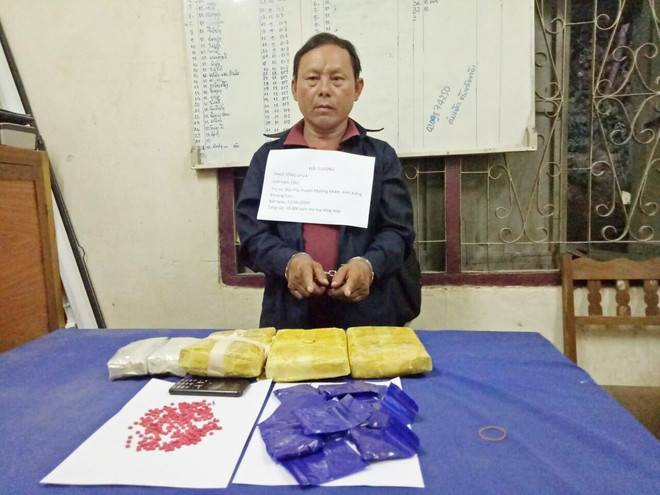 Đối tượng Thạo Tông Ly Va cùng tang vật vụ án. (Ảnh: Trịnh Duy Hưng/TTXVN) Bắt đối tượng người Lào vận chuyển 18.000 viên ma túy tổng hợp ảnh 1