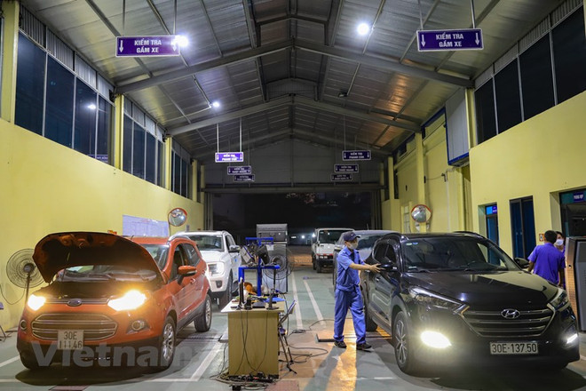 Nhân viên đăng kiểm thực hiện quy trình kiểm định xe cơ giới. (Ảnh: Hoài Nam/Vietnam+) Sớm bổ sung quy định bịt lỗ hổng quản lý đăng kiểm đường bộ ảnh 1