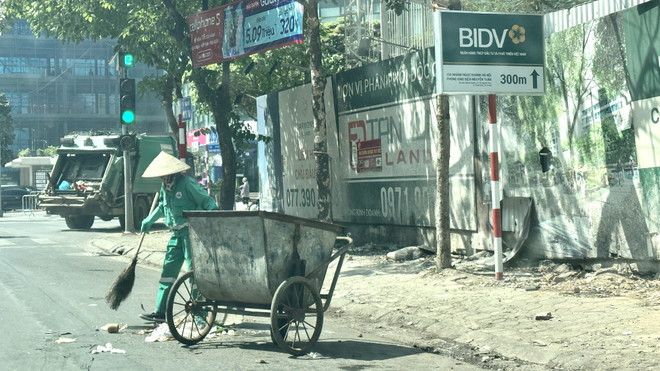 Trưa 17/5, vào lúc cao điểm của nắng nóng, công nhân môi trường vẫn vất vả thu dọn rác thải trên phố Nguyễn Tuân (quận Thanh Xuân, Hà Nội). (Ảnh: Minh Nghĩa/TTXVN) Hà Nội: Người lao động vất vả mưu sinh giữa trời nắng nóng ảnh 3