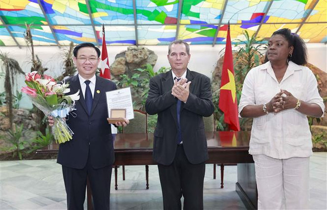 Lãnh đạo thành phố Santiago de Cuba trao kỷ niệm chương tặng Chủ tịch Quốc hội Vương Đình Huệ, vị khách danh dự của địa phương. (Ảnh: Doãn Tấn/TTXVN) Lãnh đạo Santiago de Cuba chào mừng Chủ tịch Quốc hội Vương Đình Huệ ảnh 1