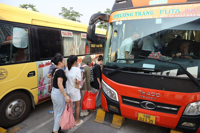 Hành khách chen chân leo lên xe để bắt đầu hành trình về quê. (Ảnh: Hoài Nam/Vietnam+) vnp_khach len ben xe.jpg