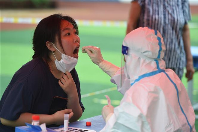 Nhân viên y tế lấy mẫu xét nghiệm COVID-19 cho người dân tại tỉnh An Huy, Trung Quốc ngày 16/7/2022. (Ảnh: THX/TTXVN) Dịch bệnh COVID-19 tiếp tục lây lan ở Trung Quốc, Hàn Quốc và Mỹ ảnh 1