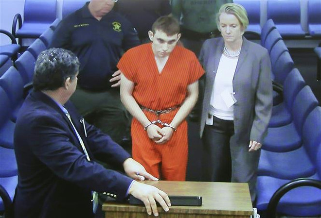 Cảnh sát áp giải đối tượng Nikolas Cruz (giữa) tới Tòa án hạt Broward, Fort Lauderdale, bang Florida ngày 15/2/2018. (Nguồn: AFP/TTXVN) Xét xử nghi phạm nổ súng ở trường học gây chấn động nước Mỹ năm 2018 ảnh 1