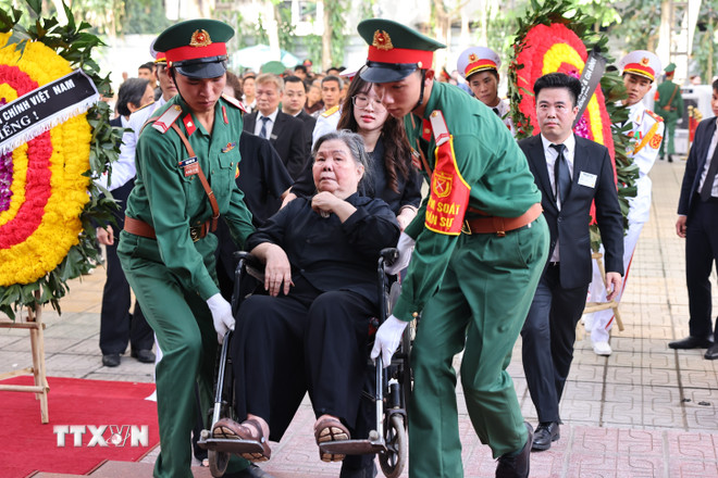 Lực lượng kiểm soát quân sự hỗ trợ, giúp bà Đặng Thị Phúc, giáo viên tiểu học của Tổng Bí thư Nguyễn Phú Trọng, năm nay đã 92 tuổi, sức khỏe đã giảm nhiều, đến Nhà tang lễ Quốc gia số 5 Trần Thánh Tông để được tiễn biệt học trò lần cuối. (Ảnh: TTXVN) TTXVN_2607cogiaoTongbithu4.jpg