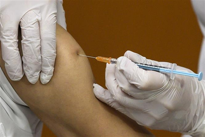 Nhân viên y tế tiêm vaccine phòng COVID-19 cho người dân tại Tokyo, Nhật Bản. (Ảnh: AFP/TTXVN) Dịch COVID-19 lắng dịu ở Nhật Bản, Cuba nhưng tăng mạnh tại Singapore ảnh 1
