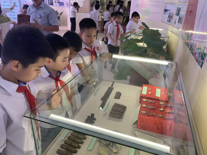 Học sinh tham quan tìm hiểu hiện vật, tài liệu lịch sử tại buổi trưng bày. (Ảnh: Hiền Anh/TTXVN) Hải Dương: Trưng bày 300 hiện vật về thực hiện Di chúc Bác Hồ ảnh 2