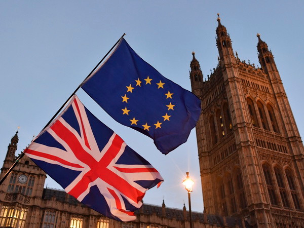 Cờ Anh (phía dưới) và cờ EU (phía trên) bên ngoài tòa nhà Quốc hội Anh ở London ngày 11/12/2017. (Nguồn: AFP/TTXVN) Nhiều nghị sỹ liên đảng Anh đòi tổ chức cuộc trưng cầu lại về Brexit ảnh 1