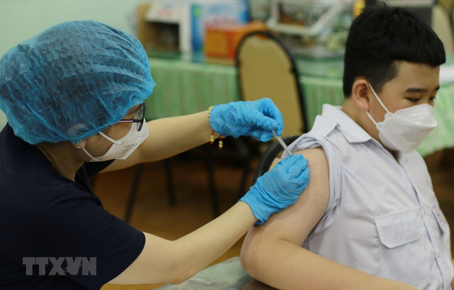 Nhân viên y tế tiêm vaccine phòng COVID-19 cho học sinh trường Trung học cơ sở Hồng Bàng (Quận 5). (Ảnh: Thu Hương/TTXVN) TP.HCM: Trẻ nhập viện do COVID-19 tăng, đa số đều chưa tiêm vaccine ảnh 1