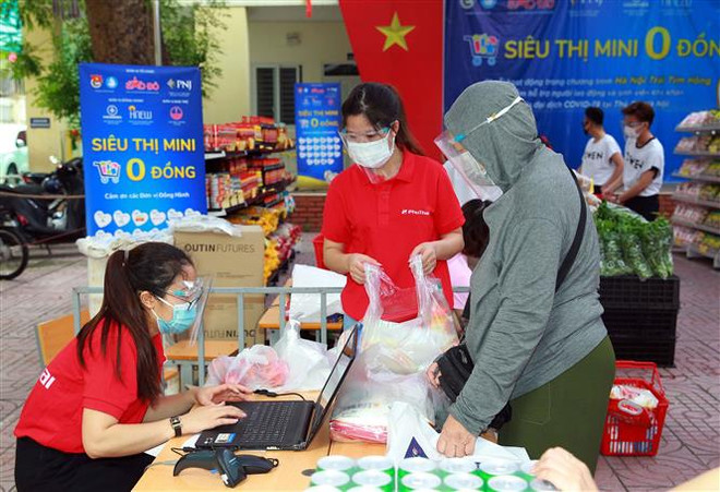 Người dân lựa chọn hàng từ siêu thị 0 đồng tại Hà Nội. (Ảnh: Trần Việt/TTXVN) Phát huy hiệu quả của mô hình "vùng xanh doanh nghiệp" tại Thủ đô ảnh 2