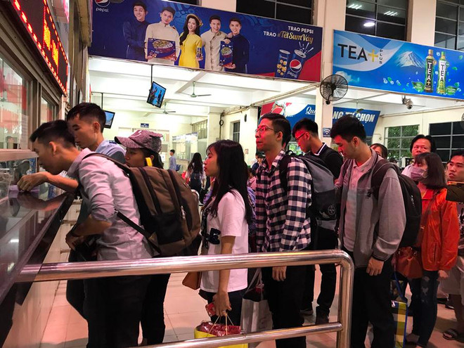 Hành khách xếp hàng dài mua vé ở bến xe Mỹ Đình. (Ảnh: Việt Hùng/Vietnam+) Tàu hỏa hết vé giường nằm, bến xe ‘lác đác’ khách về quê dịp lễ 30/4 ảnh 2