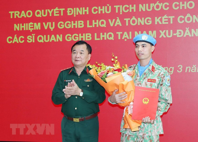 Thượng tướng Hoàng Xuân Chiến, Thứ trưởng Bộ Quốc phòng trao Quyết định của Chủ tịch nước và tặng hoa cho Thiếu tá Nguyễn Văn Phong trước khi lên đường sang Trung Phi thực hiện nhiệm vụ. (Ảnh: Trọng Đức/TTXVN) 3 Phái bộ Gìn giữ Hòa bình của VN tạo dấu ấn trên trường quốc tế ảnh 2