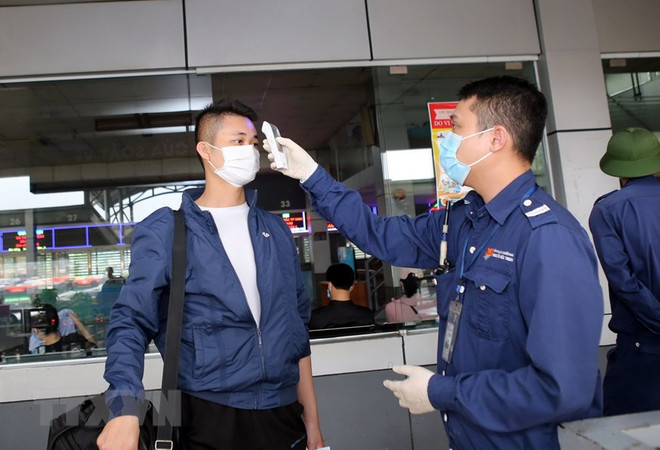 Đo thân nhiệt tại cửa soát vé tại bến xe Nước Ngầm, Hà Nội. (Ảnh: Danh Lam/TTXVN) Bộ trưởng GTVT kêu gọi người dân đi lại an toàn, gắn liền chống dịch ảnh 1