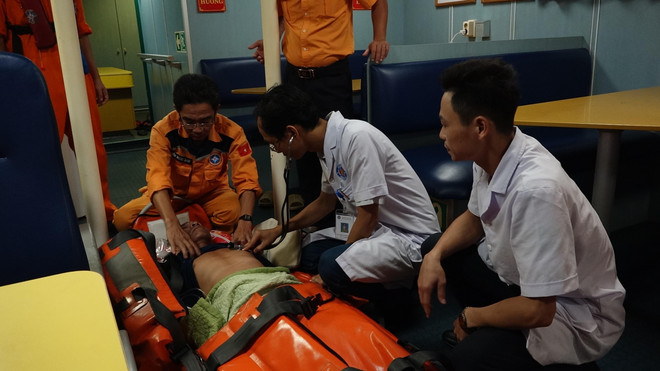 Chăm sóc y tế cho nạn nhân khi được đưa lên tàu SAR 412. (Ảnh: TTXVN) Cứu kịp thời thuyền viên bị tai biến trên vùng biển Hoàng Sa ảnh 1