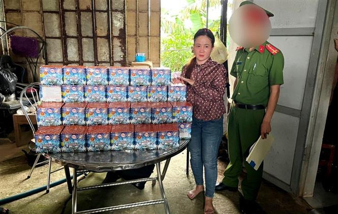 Đối tượng Trần Thị Viên bị bắt giữ cùng tang vật. (Ảnh: TTXVN phát) Bắt giữ 2 đối tượng vận chuyển, tàng trữ trái phép hơn 1,2 tạ pháo hoa ảnh 1
