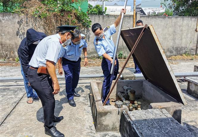 Cán bộ Cục Quản lý thị trường, Thanh tra Sở Công Thương thành phố Cần Thơ mở bồn chứa xăng Ron 95 của cửa hàng xăng dầu thuộc Công ty cổ phần Taxi Mekong ngày 15/3. (Ảnh: Thanh Liêm/TTXVN) Cần Thơ: Cửa hàng xăng dầu báo hết xăng 95 do hàng chưa về kịp ảnh 1
