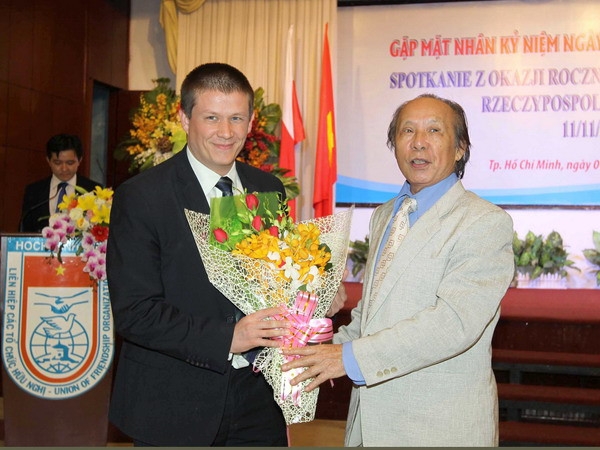 Chủ tịch Hội Hữu nghị Việt Nam-Ba Lan TP.HCM Nguyễn Đăng Cường tặng hoa chúc mừng ngài Szymon Wudarski, Phó Đại sứ Cộng hòa Ba Lan tại Việt Nam. (Ảnh: Thanh Vũ/TTXVN) TP.HCM: Gặp mặt kỷ niệm 98 năm Ngày độc lập Cộng hòa Ba Lan ảnh 1