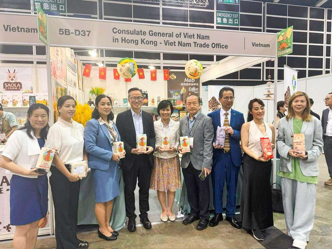Tổng Lãnh sự Lê Đức Hạnh (đứng thứ 5 tính từ bên trái) và Trưởng Thương vụ Vũ Thị Thúy (đứng thứ 3 tính từ bên trái) cùng các khách tham quan quảng bá gạo ST25. (Ảnh: TTXVN phát) st25_hoi_cho_hong_kong_lanh_su_quan.jpg