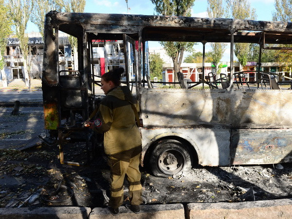 Một chiếc xe buýt bị thiêu rụi sau loạt đạn pháo tại Donetsk. (Nguồn: AFP/TTXVN) Thương vong tại miền Đông Ukraine giảm nhờ lệnh ngừng bắn ảnh 1
