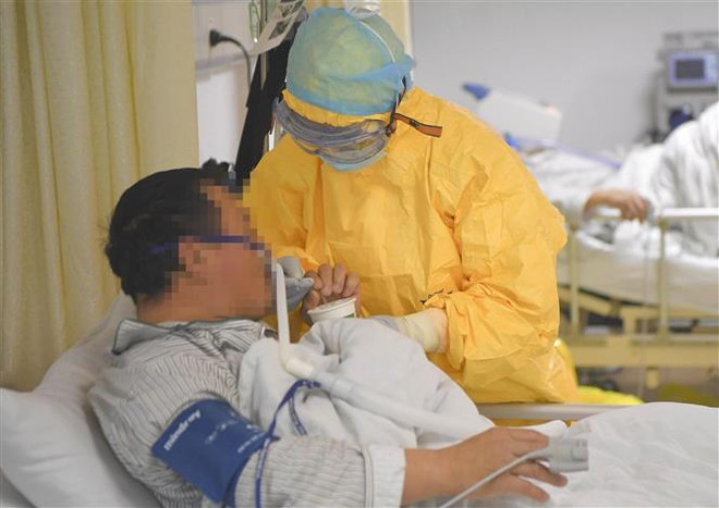 Nhân viên y tế hỗ trợ bệnh nhân nhiễm virus COVID-19 tại bệnh viện ở thành phố Trùng Khánh, Trung Quốc ngày 1/2/2020. (Ảnh: THX/TTXVN) Số ca nhiễm mới tại tâm dịch Covid-19 thấp nhất kể từ ngày 31/1 ảnh 1
