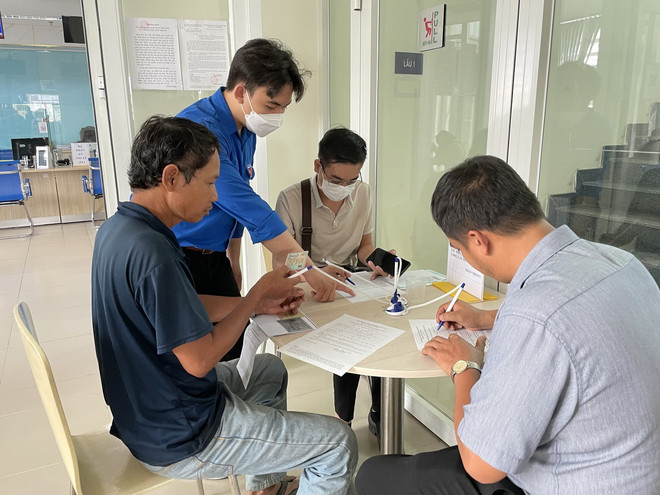 Thanh niên tình nguyện hướng dẫn người dân làm thủ tục hành chính tại Trung tâm Phục vụ Hành chính công tỉnh Đồng Nai. (Ảnh: Nhật Bình/TTXVN) thu tuc hanh chinh.jpg