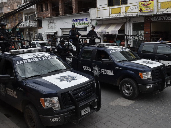 Cảnh sát liên bang Mexico gác trên một đường phố ở Teloloapan, bang Guerrero ngày 19/10. (Nguồn: AFP/TTXVN) Mexico nỗ lực điều tra vụ 43 giáo viên, sinh viên mất tích ảnh 1