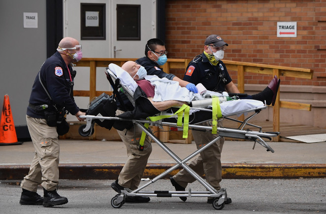 Nhân viên y tế chuyển bệnh nhân COVID-19 tới bệnh viện tại New York, Mỹ. (Ảnh: AFP/ TTXVN) Biến thể Delta chiếm 83% số ca được giải trình tự gene tại Mỹ ảnh 1