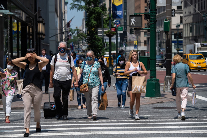 Người dân di chuyển trên một tuyến phố ở New York, Mỹ. (Ảnh: AFP/TTXVN) Dịch COVID-19: Tổng thống Mỹ cảnh báo chặng đường phía trước còn dài ảnh 1