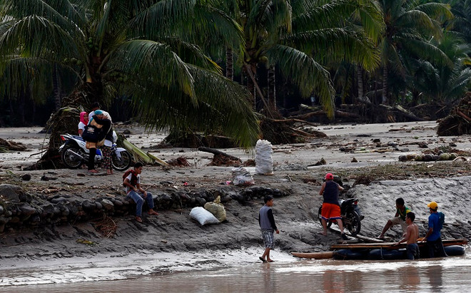 Người dân di chuyển bằng bè để qua sông sau bão Tembin tại tỉnh Lanao del Norte, Philippines ngày 23/12. (Nguồn: THX/TTXVN) Philippines: Số người thiệt mạng do bão Tembin đã lên tới 240 người ảnh 1