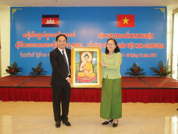 Bà Touch Sarom, Quốc vụ khanh Bộ Lễ nghi và Tôn giáo Campuchia tặng quà lưu niệm cho Ban Tôn giáo Chính phủ Việt Nam. (Ảnh: Ngọc Thiện/TTXVN) Việt Nam-Campuchia trao đổi kinh nghiệm về công tác tôn giáo ảnh 1