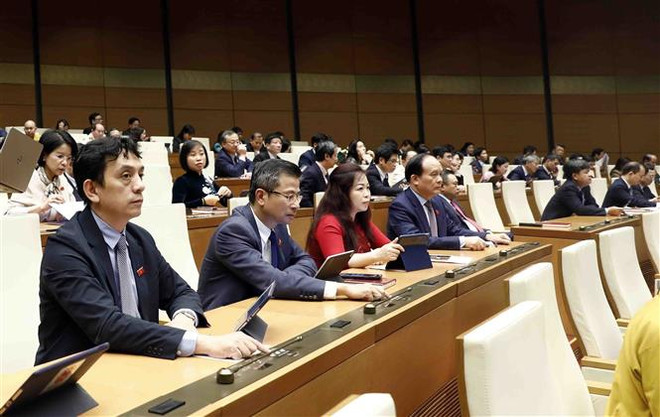 Đại biểu Quốc hội biểu quyết thông qua Nghị quyết về việc điều chỉnh kế hoạch vốn vay lại năm 2022 của các địa phương, bổ sung dự toán chi thường xuyên năm 2021 nguồn vốn viện trợ không hoàn lại của nước ngoài; điều chỉnh dự toán kinh phí chưa sử dụng hết năm 2021 của Tổng cục Thuế và Tổng cục Hải quan và việc chuyển nguồn kinh phí công tác phòng, chống dịch COVID-19 năm 2021 của các địa phương sang niên độ ngân sách năm 2022. (Ảnh: An Đăng/TTXVN) Kỳ họp Quốc hội bất thường đáp ứng yêu cầu cấp bách của thực tiễn ảnh 1